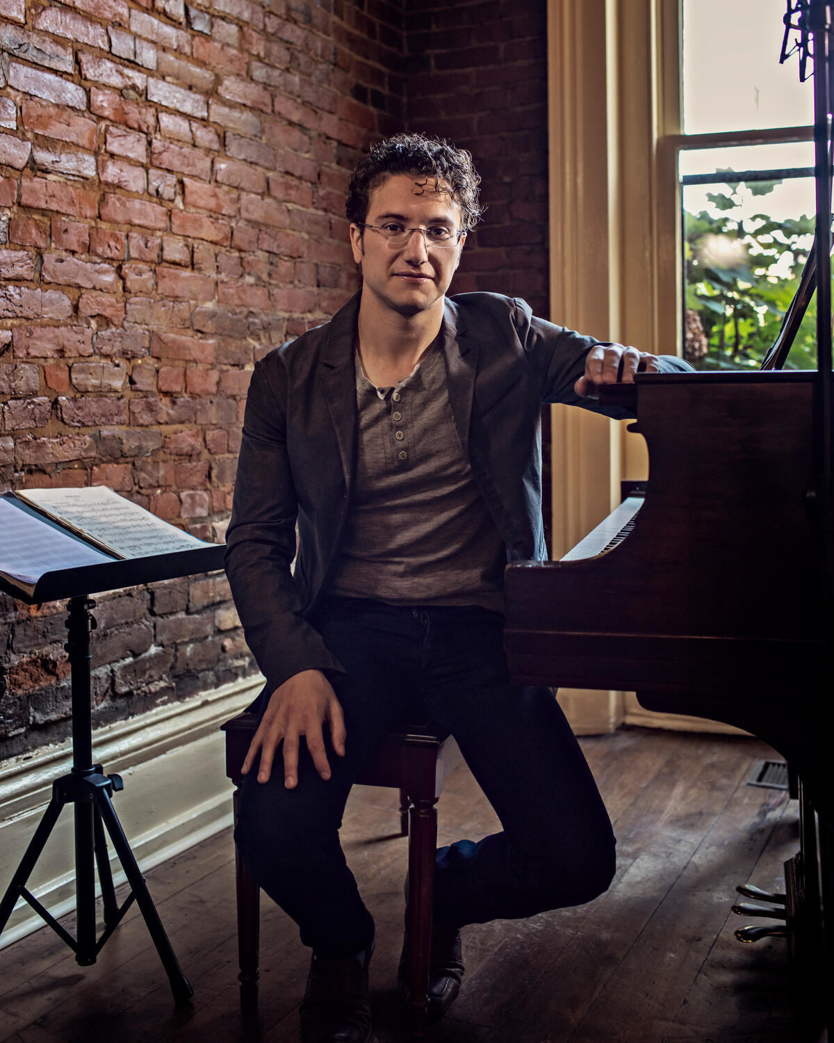 Teddy Abrams sits at a piano