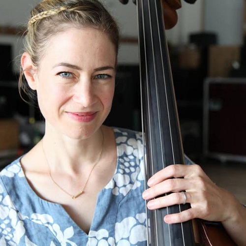A woman poses with her bass.